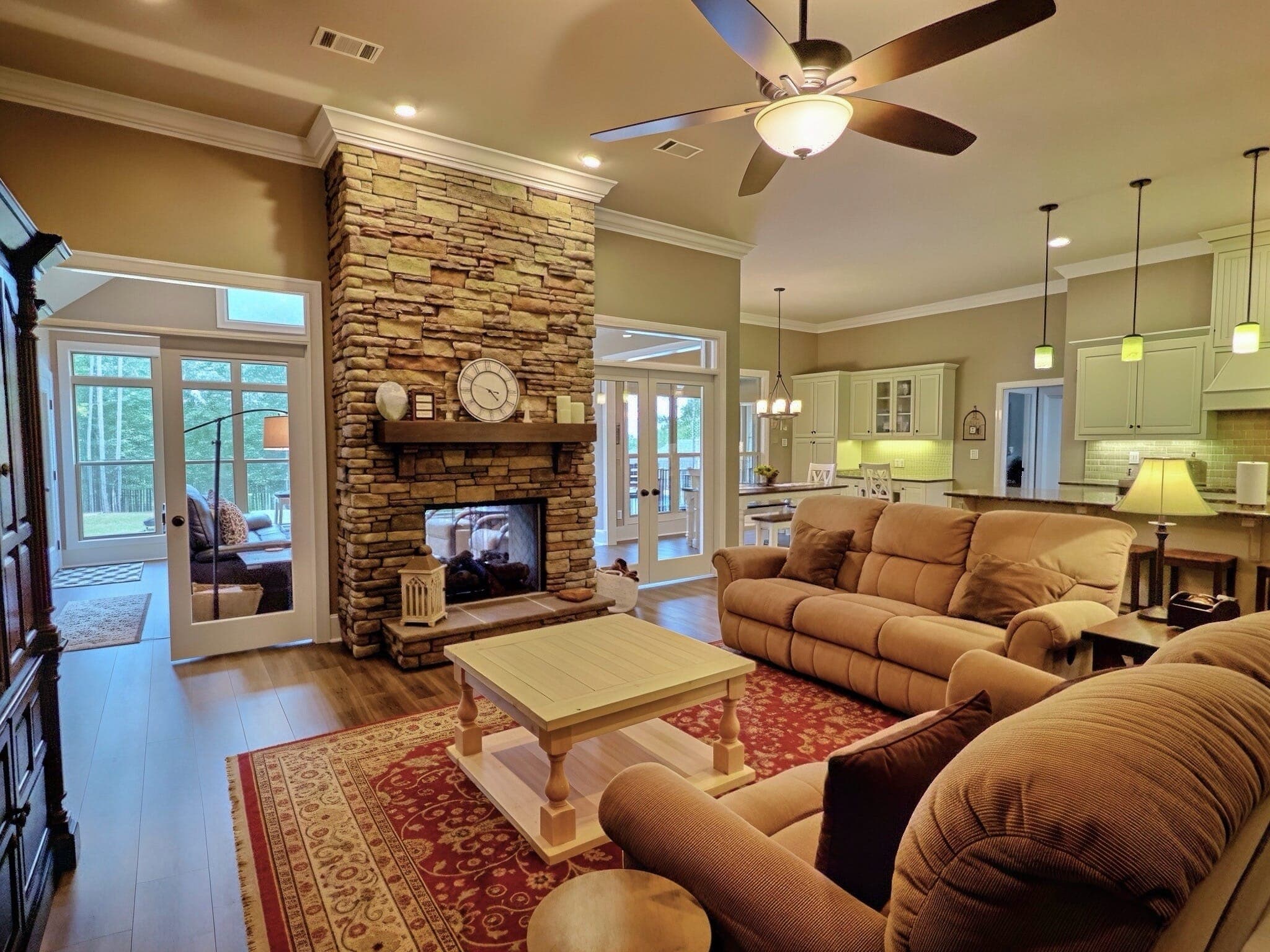 Living room at 225 Merrill Lane, with a stone fireplace and an open kitchen